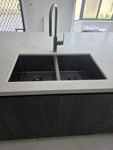 Black double kitchen sink and gooseneck mixer installed by GPS Gas & Plumbing