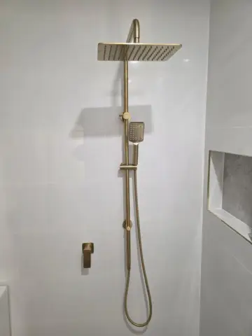 Brushed gold shower rail with rain shower rose