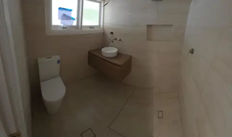 Completed bathroom renovation plumbing: toilet, floating vanity and shower