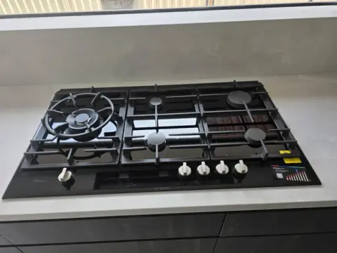 Gas cooktop with wok burner connected by a licensed gas fitter