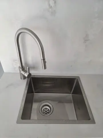 Stainless steel sink with a pull-out mixer