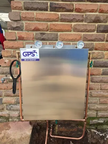 Whole-house water filter being installed with copper pipework
