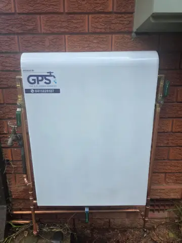 Whole-house water filtration system installed on a brick wall