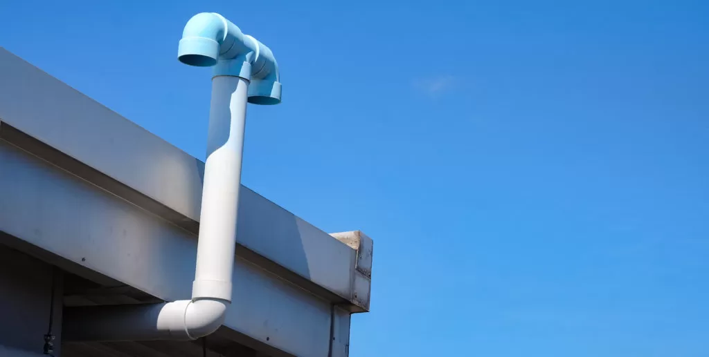 PVC pipe ventilation from the toilet in the building on blue sky background